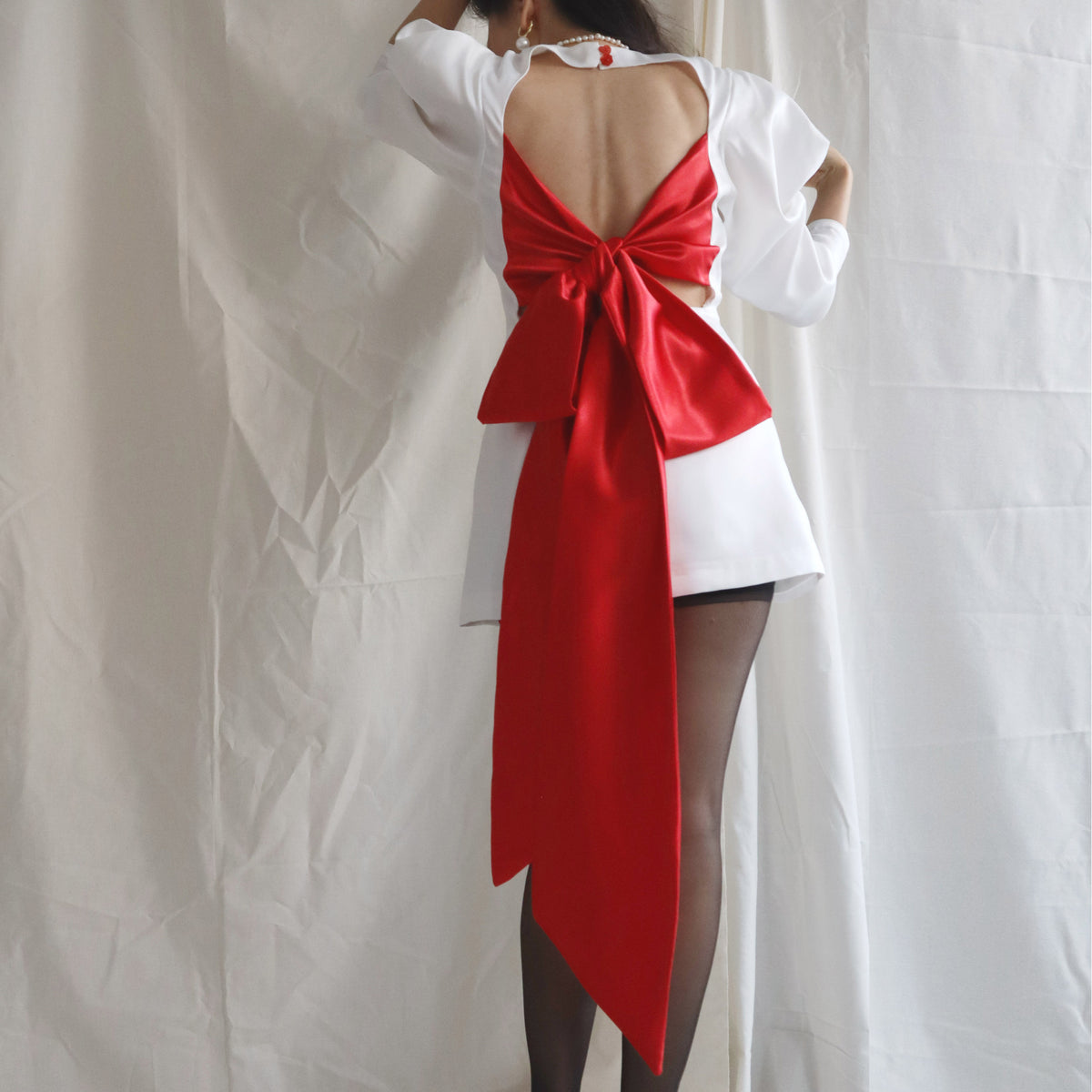 Back view of the Harper backless dress with oversized red bow