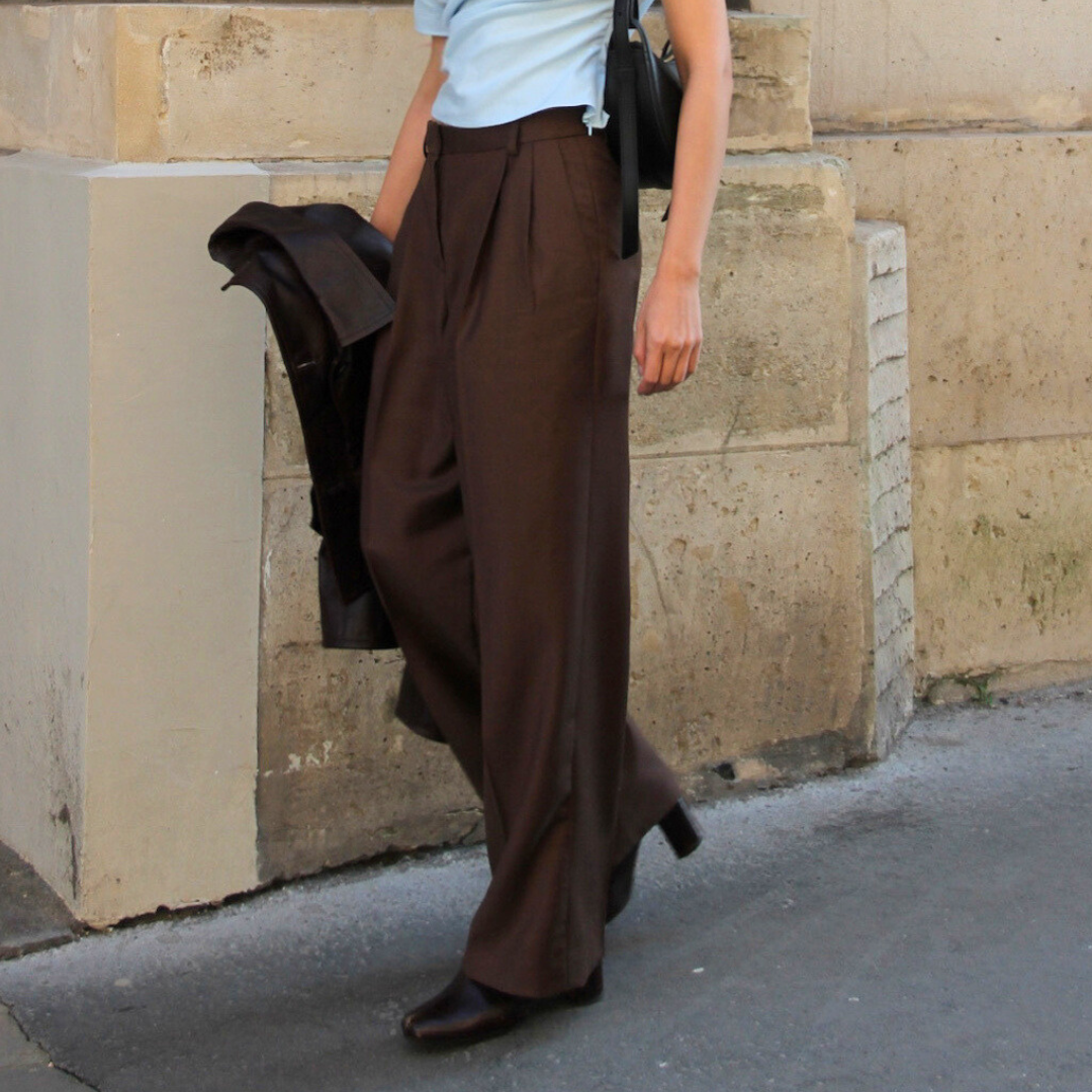 Brown It Girl Pants with pressed creases, worn with a blue top