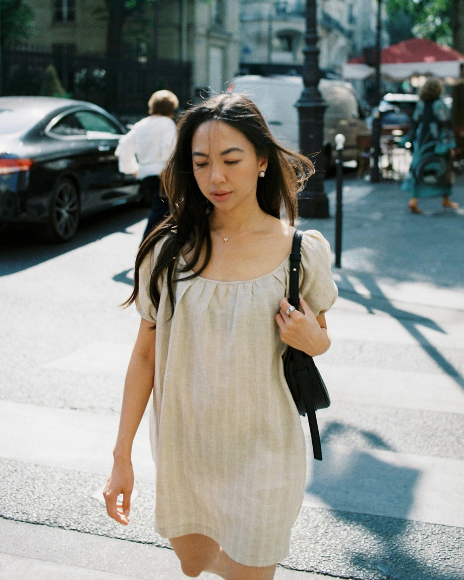 Lizzie walking down a Paris street in a linen dress