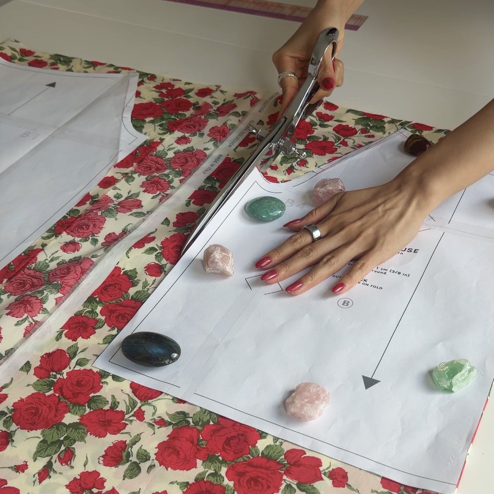 Lizzie cutting rose-print fabric with pattern pieces