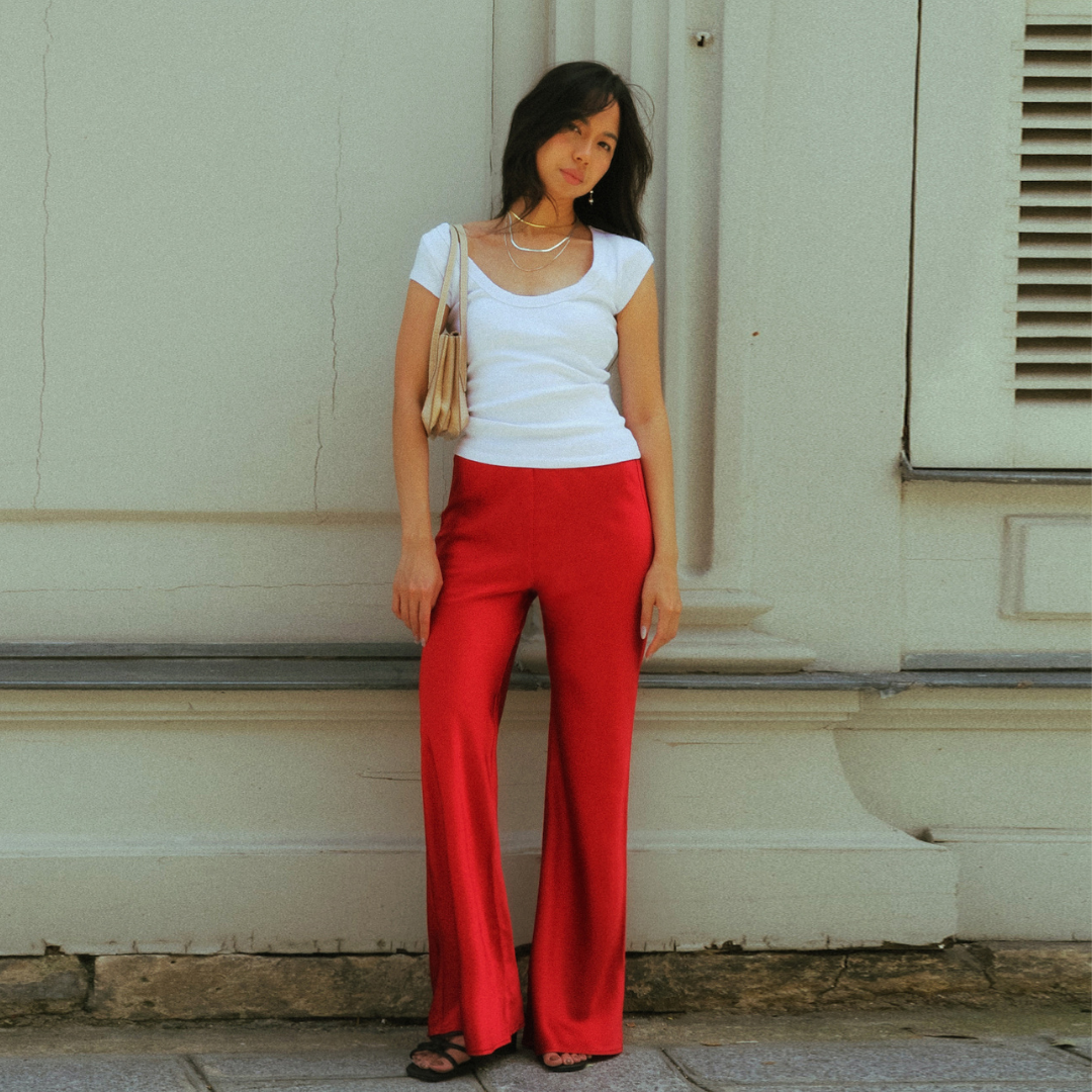 Red satin Vela Bias Pants worn with a white top